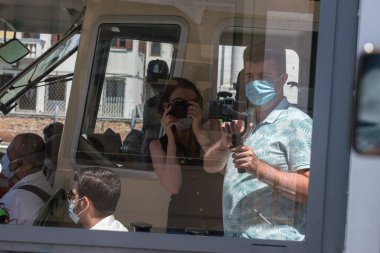 İtalya, Venedik 23 Temmuz 2020: Yazın Meşhur İtalyan Venedik 'in Editör Görüntüsü. Venedik Halk Su Otobüsü Vaporetto 'su ve tıbbi maskeli turistler. Karantina Turizmi