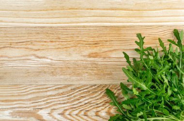 Arugula ahşap masa maketinde. Taze roka, roka yaprakları, roka, eruca ya da ahşap arka planda roket salatası.