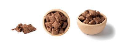 Kahvaltı için beyaz arka planda izole edilmiş çikolata yastıkları. Yuvarlak ahşap kasede kremalı kahverengi çikolata gevrekleri gevrek mısır gevrekleri, sağlıklı tatlı atıştırmalık üst manzara.