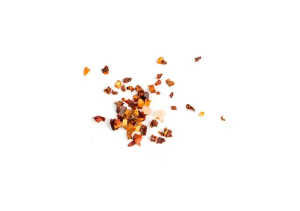 Red chilli pepper flakes with seeds isolated. Pile of broken crushed hot red pepper, dried chili flake with pink salt pieces top view