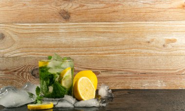 Soğuk buzlu mojito, limonlu içecek, naneli limonata veya ahşap kırsal arka planda limonata kokteyli.