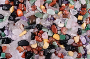 Renkli taşlar arka plan dokusu. Yeşil, kırmızı, mavi, beyaz, siyah ve mor kuvars taşları üst görünümü karıştırır