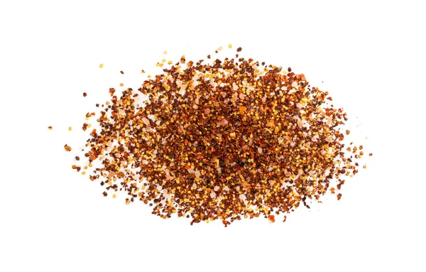 Red chilli pepper flakes with seeds isolated. Pile of broken crushed hot red pepper, dried chili flake with pink salt pieces top view