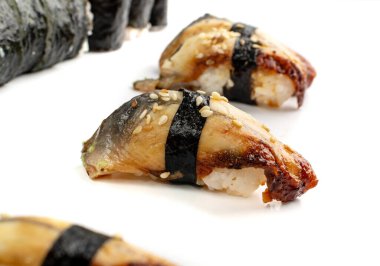 Beyaz arka planda izole edilmiş yılan balığı suşisi. Unagi nigiri, füme yılan balığı ve pirinç ile yakın plan.