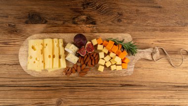 Peynir tabağı çeşitliliği, sarı, beyaz ve mavi gorgonzola tabağı, Munster, dört peynirli pano, çeşitli doğranmış süt ürünleri, ahşap üzerinde kokulu Fransız peyniri.