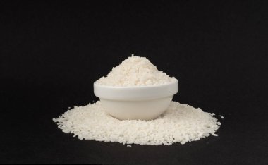 Kavanozda rendelenmiş hindistan cevizi tozu. Kuru Coco Flakes yığını, parçalanmış Hindistan cevizi, tropikal meyve cipsi dokusu, siyah arka planda tıraşlanmış fındık.