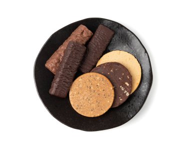 Protein çubuğu ve kurabiye seti, farklı enerji paleo atıştırmalıkları, çeşitli sağlıklı mısır gevreği gözlemeleri, siyah tabakta tatlı bir kahvaltı, beyaz arka plan manzarası.