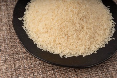 Siyah tabakta haşlanmış pirinç taneleri yakın plan. Kurutulmamış ponni pilavı, küçük organik basmati, geleneksel Asya malzemesi makro.