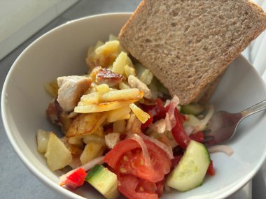 Tavuk fileto, domates ve salatalık salatası ile kızarmış patates şeklinde popüler bir Slav yemeği. Yüksek kalorili ve lezzetli bir ev yemeği.