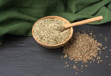 Kabuklu kenevir tohumları, soyulmuş kenevir taneleri, kabuksuz marihuana çekirdekleri, siyah arka planda yağlı protein kenevir tohumları.