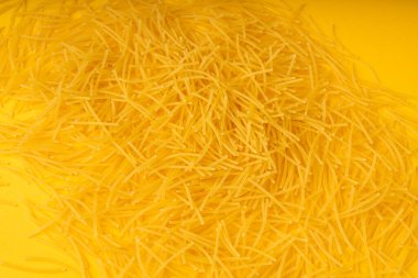 Çiğ vermicelli desenli arka plan, altın çorbalı makarna deseni, küçük ev yapımı erişte makarnası, ince makarna pankartı, metin için fotokopi alanı olan İtalyan sarı makarna.