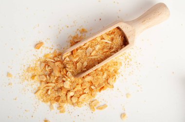 Kuru sarımsak dilimleri yalıtılmış, ahşap kepçe içinde çıtır çıtır kızartılmış karanfil, ızgara sarımsak gevreği, karanfil grubu beyaz arka plan üst görünümü