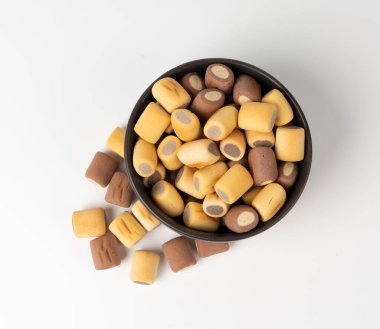 Dolu köpek bisküvileri, izole krakerler, yumuşak gevrek evcil hayvan ziyafetleri, aromalı küçük köpek bisküvileri, doldurulmuş bisküviler, beyaz arka planda köpek maması eğitimi.