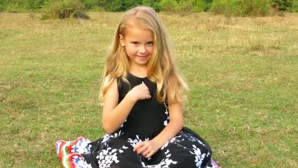 Petite fille montre avec des gestes "je t'aime" . — Video
