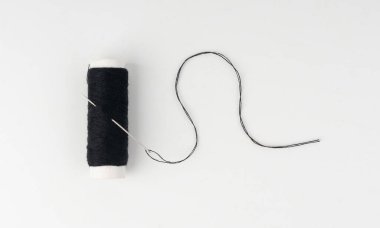 İğne ve siyah iplik izole edildi. Beyaz arka planda iğne, dikiş malzemesi, renkli pamuk ipliği, iş malzemesi ve terzilik sektörü sembolü