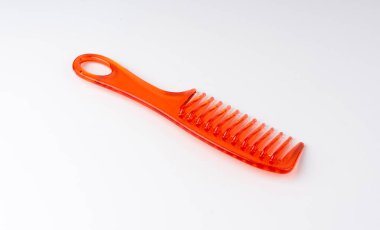 Turuncu plastik tarak izole edildi. Yeni renk saç fırçası, renkli berber aracı, beyaz arkaplanda büyük kırmızı tarak
