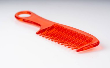 Turuncu plastik tarak izole edildi. Yeni renk saç fırçası, renkli berber aracı, beyaz arkaplanda büyük kırmızı tarak