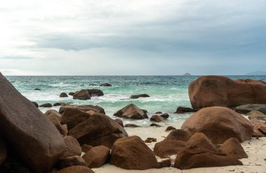 Büyük kayalıkları, turkuaz denizi, kumlu kıyıları, parlak gökyüzü altındaki uzak adaları, seyahat, tatil, doğa ve deniz manzarası temaları için ideal tropikal kıyıları