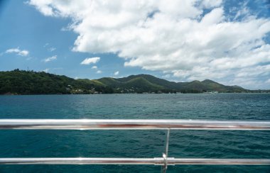 Baie Sainte Anne Köyü ve Praslin Adası 'ndaki tepeler Seyşeller' de önünde paslanmaz demiryolu olan bir feribottan izlendi.