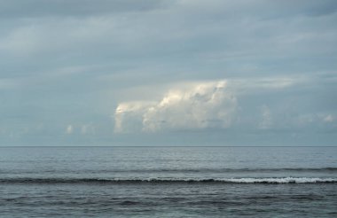 Hint Okyanusu üzerinde güneş tarafından aydınlatılan parlak yağmur bulutu, tropik cennet adaları üzerinde kötü hava.