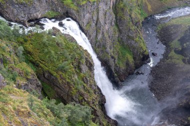 Voringfossen şelalesi Eidfjord, Norveç 'te, Hardangervidda platosundan derin bir kanyona dökülüyor. Uçurumları ve nehir akışı olan manzaralı dağ manzarası