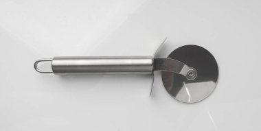 Pizza kesicisi izole. Yuvarlak tekerlekli yuvarlak tekerlekli bıçak, metal bıçaklı çatal bıçak, beyaz arka planda pizza kesmek için krom İtalyan aletleri.