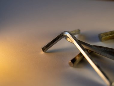 Metal büyü tuşları pürüzsüz bir yüzeyde yumuşak bir şekilde yatar. Sıcak ışık, cilalı ve hassas kenarlarını vurgular. Araçlar el değmemiş ve hazır bir şekilde sessizliğin içinde dinleniyor. Teknik, onarım ve atölye resimleri için ideal