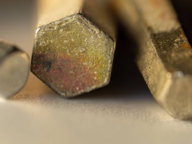 Altıgen metal çubuklar yan yana uzanıyorlar. Yüzey gösterileri yıpranma, paslanma ve ezilme gösteriyor. Işık dokuyu ve kenarları hafifçe vurgular. Endüstriyel dayanıklılık bu kadar yakından hissedilebilir. Tasarım ve mühendislik için kullan