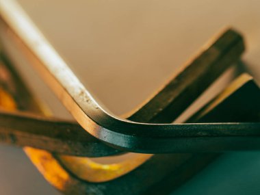 Metal kenarlar sıcak ışık altında hafifçe parlar. Açılar kıvrımlı, ustalık ve hassasiyete işaret ediyor. Dokular cilalanmaktan yıpranmaya geçer, bu da kullanıldığını gösterir. Yakın çekim endüstriyel zarafeti yakalar