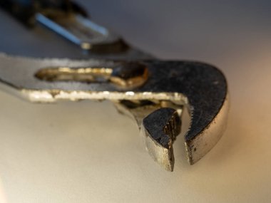 Yıpranmış kenarları olan yıpranmış metalik İngiliz anahtarı. Araç, ağır kullanım ve kaba kullanım belirtileri gösteriyor. Yumuşak ışıklandırma dokuyu ve küçük yüzey aşınmasını ön plana çıkarır. Tamir ve bakım için ideal.