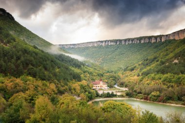 Bulutlu havalarda göl kenarında ev.