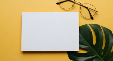 Temiz ve minimalist bir maket, beyaz bir kart, bir canavar yaprağı ve parlak sarı bir arka planda sıralanmış gözlükler, vitrin tasarımları için mükemmel..