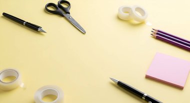 Sarı bir yüzeye yerleştirilmiş kalem, kalem, makas, bant ve yapışkan notlar içeren kırtasiye malzemelerinin yukarıdan çekimi, bir çalışma alanı düzlemi oluşturur.