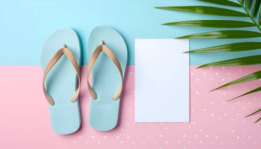 Bir çift açık mavi parmak arası terlik, bir palmiye yaprağı ve boş bir beyaz kart, yaz ve tropikal bir hissi çağrıştıran, pastel pembe ve mavi bir arka planda düzenlenir..