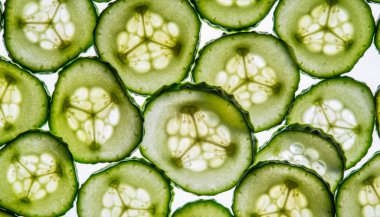 Yakın plan salatalık dilimleri, onların hassas iç yapısını ve canlı yeşil rengini gözler önüne sererek, görsel olarak çekici ve ferahlatıcı bir kompozisyon oluşturur..