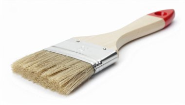 Beyaz arka planda izole edilmiş, tahta saplı ve kırmızı aksanlı temiz bir boya fırçasının yakın çekimi..