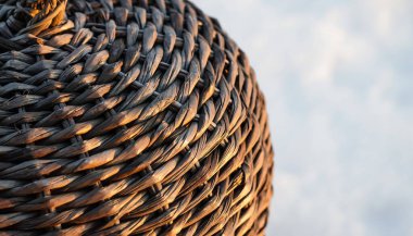 Detaylı bir yakın çekim doğal bir lif sepetinin karmaşık dokuma desenini, dokuyu ve işçiliği vurguluyor..