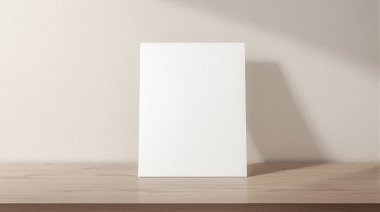 Temiz, boş beyaz bir kart ya da kağıt, ahşap bir yüzey üzerinde dimdik durur. Arkasındaki duvarda yumuşak bir gölge olan yumuşak ışıkla yıkanır..