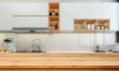 Temiz, modern bir mutfak. Sıcak ahşap bar tezgahı ve sakin ve çağdaş bir görünüm için yumuşak arka plan cihazları var..