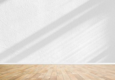 A clean bright interior featuring a light gray wall and warm wooden floor with soft shadows, perfect as a versatile background or product showcase.