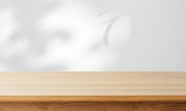 Yumuşak bulanık arkaplanı olan temiz ahşap bir masa, sakin bir çalışma alanı izlenimi yaratıyor.