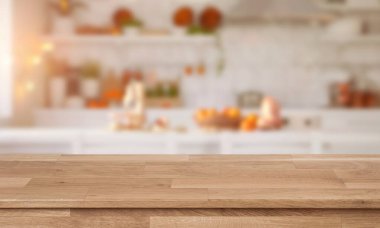 Ön planda ahşap bir tezgahın olduğu samimi bir fırın sahnesi ve arka planda sıcak ışıkla bulanık pasta rafları..