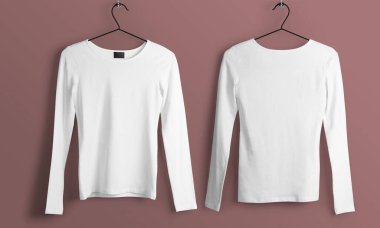 Birbirinin aynısı iki uzun kollu gömlek ahşap askılarda pembe bir zemine karşı yan yana asılı..