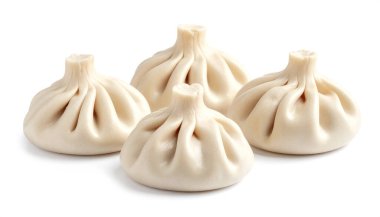 Bir grup yumuşak buğulanmış hamur köftesi beyaz bir yüzeyde oturur, hassas kıvrımları ve geleneksel hamur dokusunu vurgular..