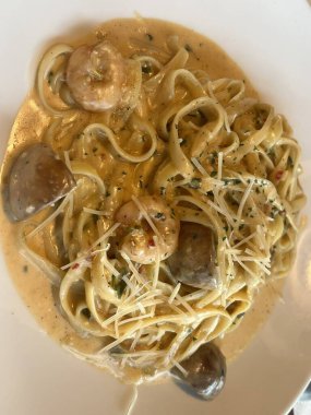 Lezzetli beyaz bir sosla kaplanmış kremalı ve zengin spagetti rahatlatıcı ve tatmin edici bir yemek için mükemmel bir lezzet sunuyor..