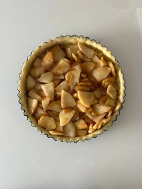 Beyaz mutfak masasında taze elmalı ev yapımı elmalı turta, üst manzara, düz yatak. Şükran Günü geleneksel tatlı, Şükran Günü turtası hazırlama, sonbahar fırını. Kıtır kıtır hava tatlısı. Tarif