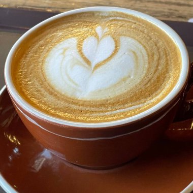 A beautifully crafted latte, featuring creamy foam art on top of rich espresso. Perfect for coffee related projects, this image captures the warmth and inviting nature of a classic cafe experience.