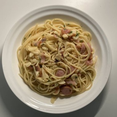 Bir tabak spagetti makarnası, mükemmel pişirilmiş ve üzerine bol marinara sosu ve taze otlar konmuş. Yemek fotoğrafçılığı ve menüler için ideal, İtalyan mutfağının kalbini lezzetli bir şekilde yakalamak..