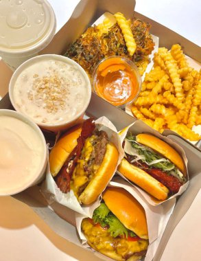 Kızarmış patateslerin yanında taze malzemelerle servis edilen sulu bir hamburgerin klasik kombinasyonu. Lezzetli tatları ve çıtır çıtır dokuları harmanlayan doyurucu bir yemek için mükemmel..