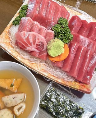 Taze ve narin sashimi dilimleri, canlı renkler ve mükemmel kesimlerle güzelce sunuluyor. Bu geleneksel Japon lezzeti kaliteli deniz ürünlerinin saf tatlarını vurgular..